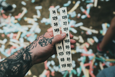 Talonarios de rifa personalizados: mano sosteniendo tickets de rifa numerados entre confeti