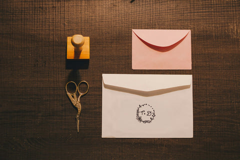 Timbre de goma personalizado junto a papelería, como el timbre para bolsas y cajas